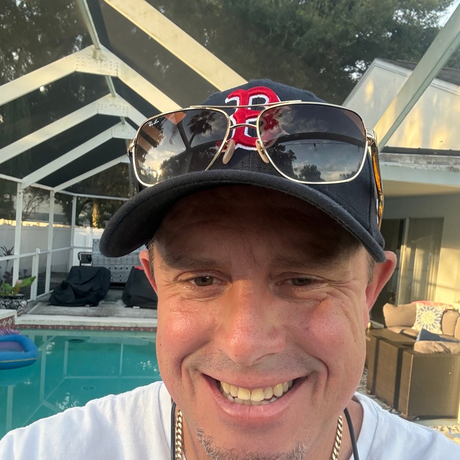 Dewey Kopenga, Tampa Bay realtor, poolside in a Boston ball cap